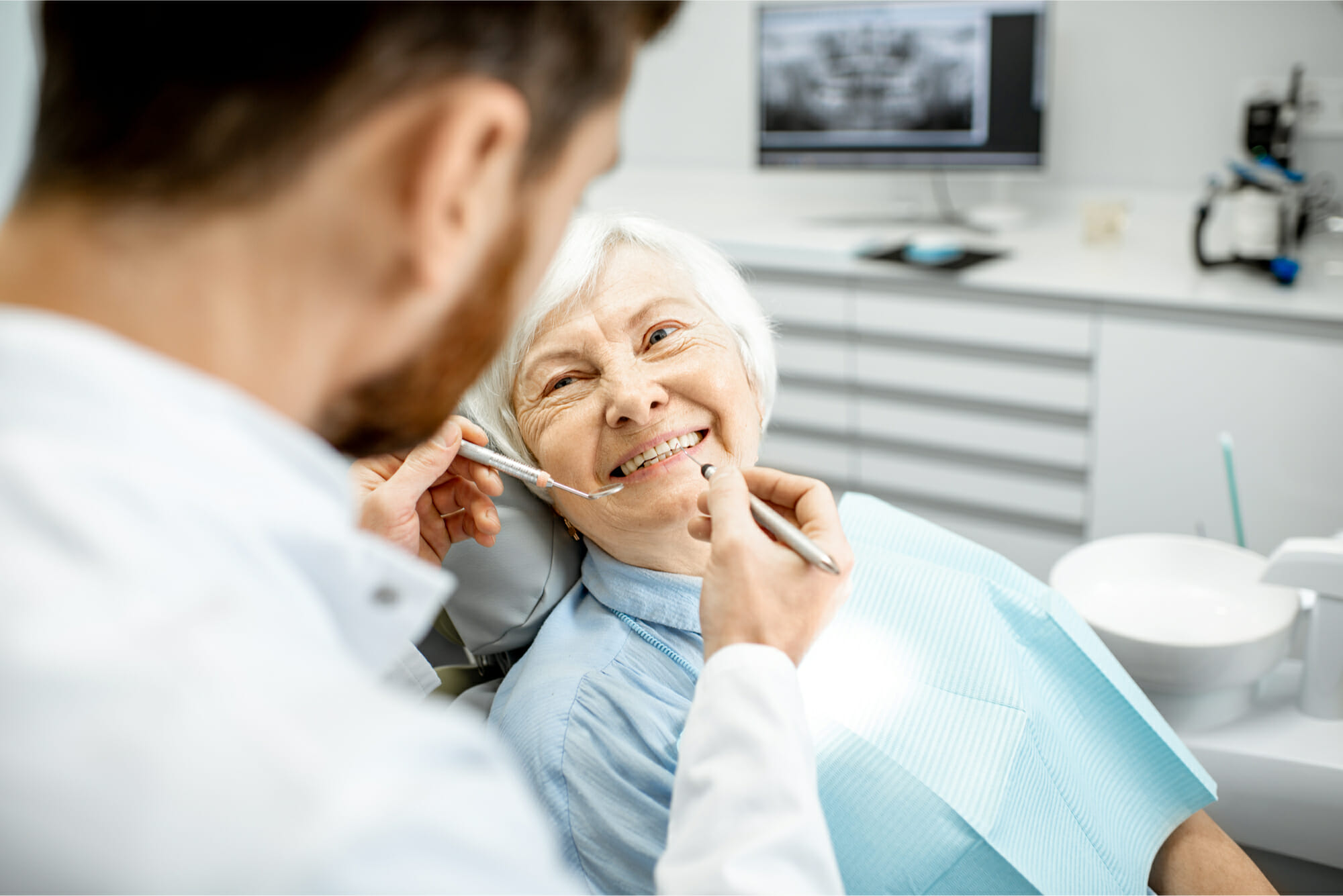 older woman smiling at dentist